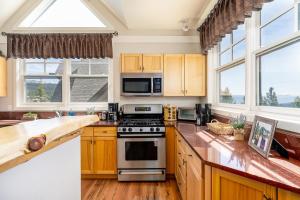 a kitchen with wooden cabinets and a stove top oven at Saddle Ridge V2 by Moonlight Basin Lodging in Big Sky