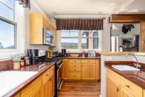 a kitchen with wooden cabinets and a large window at Saddle Ridge V2 by Moonlight Basin Lodging in Big Sky