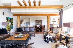 a living room with leather furniture and a table at Saddle Ridge V2 by Moonlight Basin Lodging in Big Sky