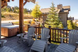a deck with two chairs and a hot tub at 5 Bandit Way by Moonlight Basin Lodging in Big Sky