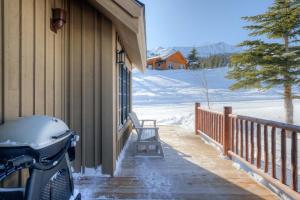 a snow covered porch of a house with a snow bike at 5 Bandit Way by Moonlight Basin Lodging in Big Sky