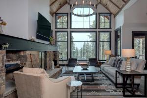 a living room with a stone fireplace and a couch at 6 Jakes Lane by Moonlight Basin Lodging in Big Sky