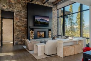 a living room with a fireplace and a tv at 7 Speedwell Drive by Moonlight Basin Lodging in Big Sky