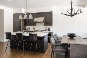 a kitchen with black cabinets and a table with chairs at 16 Wildwood by Moonlight Basin Lodging in Big Sky