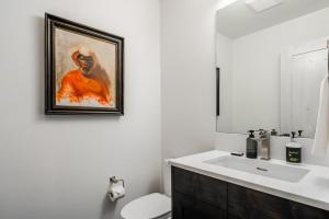a bathroom with a sink and a painting on the wall at 16 Wildwood by Moonlight Basin Lodging in Big Sky