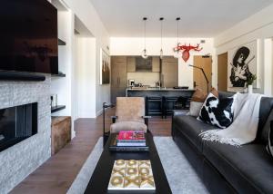 een woonkamer met een bank en een open haard bij 215 LakeLodge by Moonlight Basin Lodging in Big Sky