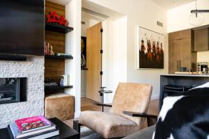 een woonkamer met een open haard en een stoel bij 215 LakeLodge by Moonlight Basin Lodging in Big Sky