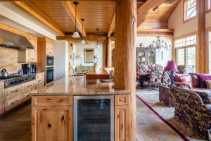 a kitchen with wooden cabinets and a living room at Penthouse 4 by Moonlight Basin Lodging in Big Sky