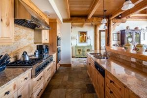 cocina con armarios de madera y horno con fogones en Penthouse 4 by Moonlight Basin Lodging en Big Sky