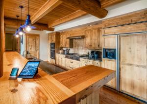 una cocina con encimera de madera y ordenador portátil. en Penthouse 3 by Moonlight Basin Lodging en Big Sky