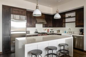 a kitchen with a large white island with bar stools at 4B Lodgeside by Moonlight Basin Lodging in Big Sky