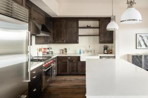 a kitchen with wooden cabinets and a white counter top at 4B Lodgeside by Moonlight Basin Lodging in Big Sky
