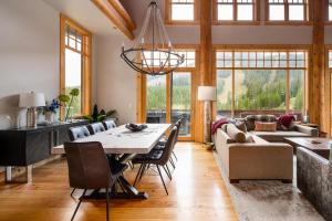 a dining room and living room with a table and chairs at Penthouse 1 by Moonlight Basin Lodging in Big Sky