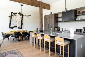 een open keuken en eetkamer met een groot kookeiland met barkrukken bij 232 LakeLodge by Moonlight Basin Lodging in Big Sky