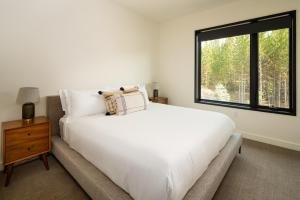 Un dormitorio con una gran cama blanca y una ventana en 221 LakeLodge by Moonlight Basin Lodging, en Big Sky