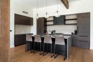 een keuken met een eiland met barkrukken bij 212 LakeLodge by Moonlight Basin Lodging in Big Sky
