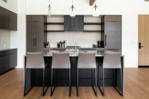 een keuken met een zwart eiland met barkrukken bij 212 LakeLodge by Moonlight Basin Lodging in Big Sky