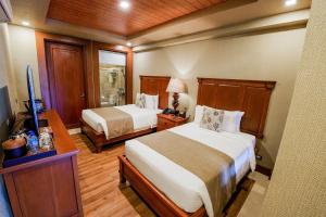 a hotel room with two beds and a television at Highland Bali Villas, Resort and Spa 