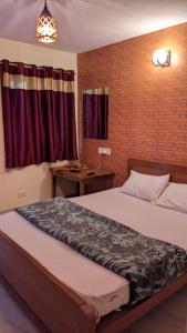 a bedroom with a bed and a brick wall at Cloudsmisty kodai in Kodaikānāl