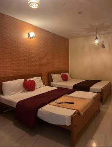 a bedroom with two beds with red pillows on them at Cloudsmisty kodai in Kodaikānāl