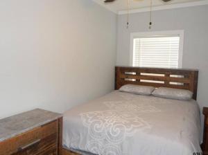 a bedroom with a bed and a dresser and a window at Lake Front Lake House Paradise! in Pittsburg