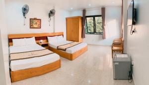 a bedroom with two beds and a trash can at Galaxy Home - Hotel Sky view in Cat Ba