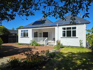 a house with solar panels on the roof at Aspiring Villa Apartment in Christchurch