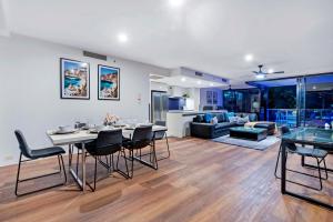 een woonkamer met een tafel en stoelen en een bank bij Pool View, Low Floor Apartment at Circle on Cavill - Wow Stay in Gold Coast
