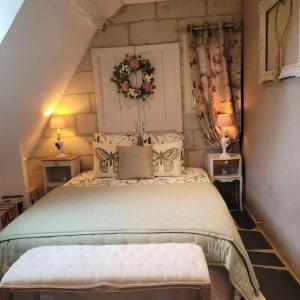 ein Schlafzimmer mit einem großen Bett mit einem Kranz darauf in der Unterkunft Gîte de charme, bord de Loire Ma Maison Angevine in Le Thoureil