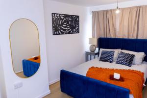 a bedroom with a blue bed and a mirror at Elegant 3 bed house in the heart of London in London