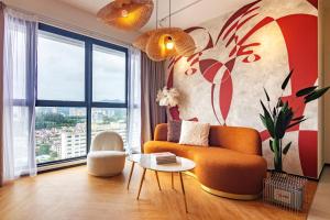 a living room with a couch and a large window at Urban Suites, Signature Collection by Stellar ALV in Jelutong
