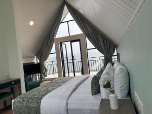 um quarto com uma cama e uma janela grande em Hummingbird St.Clare Villas em Dimbula