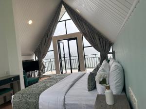 a bedroom with a bed with a large window at Hummingbird St.Clare Villas in Dimbula