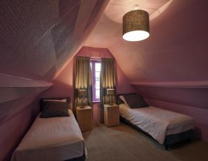 two beds in a room with purple walls at Gîte Salamandre - 8 Personnes in Chambord