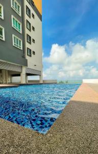 a hotel with a swimming pool next to a building at Inap Tanjung Homestay in Kuala Terengganu