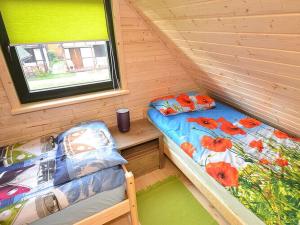una camera con 2 letti in una baita di tronchi di Comfortable holiday house with a garden, D bki a Dąbki