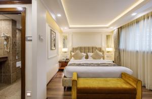una camera d'albergo con letto e doccia di Hotel Shanker-Palatial Heritage Kathmandu a Kathmandu