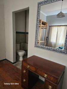 een badkamer met een houten dressoir en een spiegel bij The Witch's Inn in Philippolis