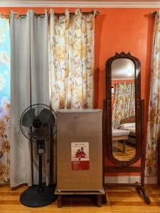 a fan and a mirror in a room at Cardo Homestay Siargao in General Luna