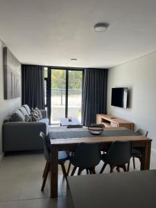 ein Wohnzimmer mit einem Tisch, Stühlen und einem Sofa in der Unterkunft Flat 2 Block 15 Bellamare in Port Elizabeth