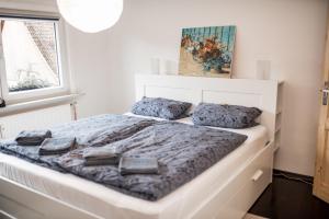 a white bed with blue blankets and pillows on it at Stadt-Ferienwohnung in Bad Lauterberg
