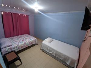 Habitación pequeña con 2 camas y lámpara en Bread Fruit Lodge en San Andrés