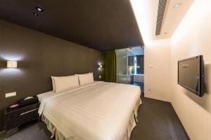 a bedroom with a large bed and a television at 凡登台北商務旅店 in Taipei