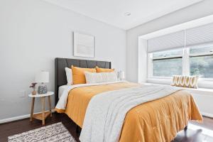 a bedroom with a large bed with an orange blanket at The BEST Gorgeous & Luxurious Home Walk to Metro in Arlington