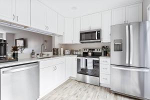 a kitchen with white cabinets and stainless steel appliances at The BEST Gorgeous & Luxurious Home Walk to Metro in Arlington