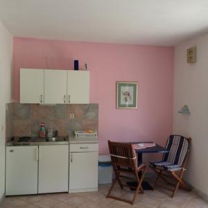 a kitchen with white cabinets and a table and chairs at Apartment Kordić in Sveta Nedelja