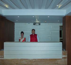 a man and a woman standing behind a counter at Hotel S R Castle in Port Blair
