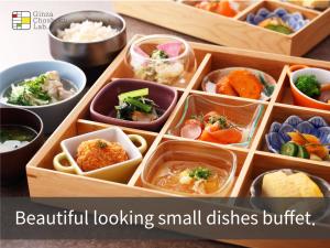 una scatola di legno piena di piccoli piatti di cibo di Hotel Musse Ginza Meitetsu a Tokyo