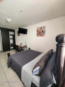 een slaapkamer met een groot bed en een tafel met een bureau bij Casa Hany in Panama-Stad