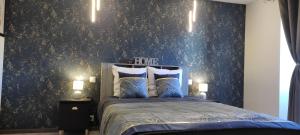 a bedroom with a bed with blue floral wallpaper at Les Souvenirs d'Alsace in Colmar